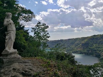 Statue by trees against sky