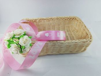 High angle view of pink roses in basket on table