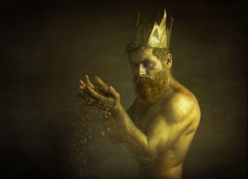 Portrait of young man holding cigarette over black background