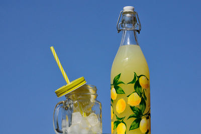 Close-up of glass bottle against blue sky
