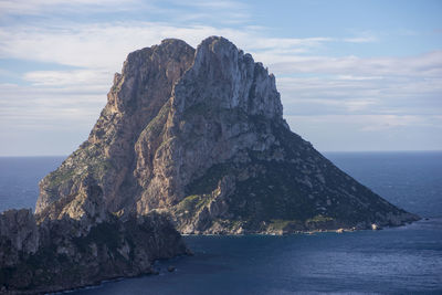 Rock formation in sea against sky