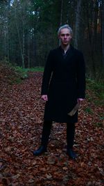 Portrait of young woman standing in forest