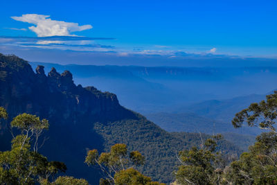 Scenic view of mountains against blue sky
