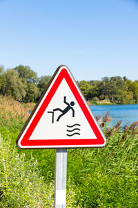 Information sign by road against sky