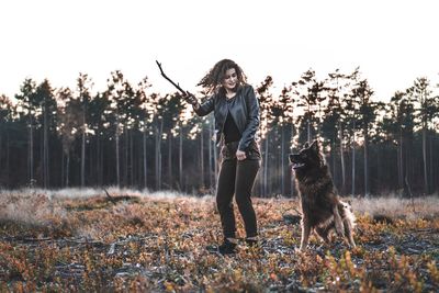 Woman playing with hyena in forest