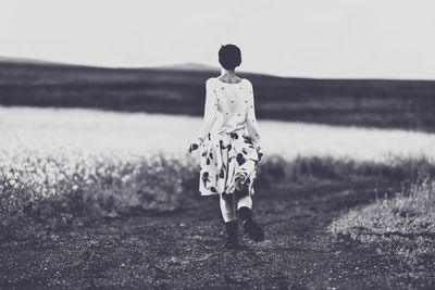 Rear view of a man walking on field