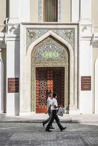 Full length rear view of man walking outside building