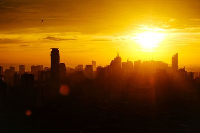 Silhouette buildings against romantic sky at sunset