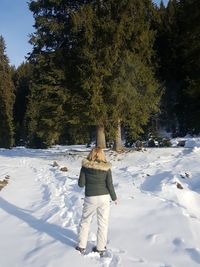 Rear view of woman on snow covered field