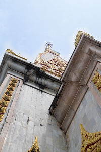 Low angle view of sculptures on building against sky