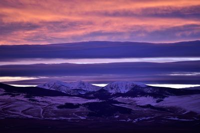 Scenic view of snowcapped mountains against sky during sunset