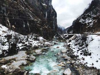 Stream flowing through rocks during winter