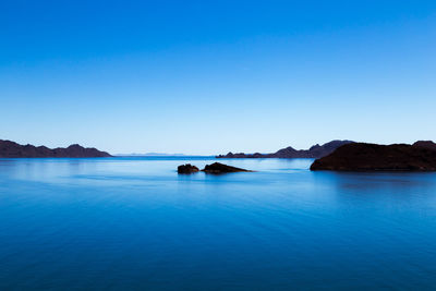 Scenic view of sea against clear blue sky