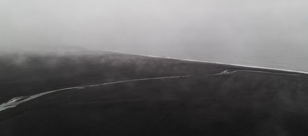 Airplane flying over landscape against sky