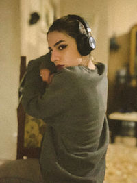 Portrait of woman with arms raised at home