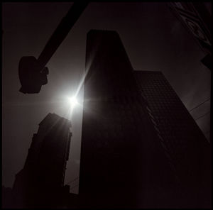 Low angle view of silhouette building against bright sun