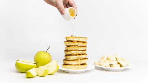 Midsection of person holding apple against white background