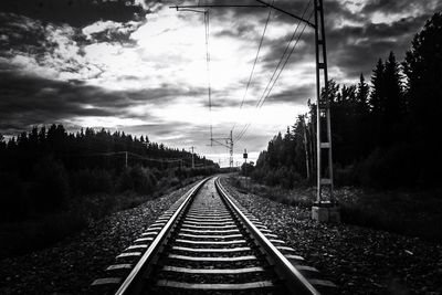 Railroad track against cloudy sky