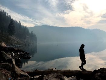 Man standing on lake against sky