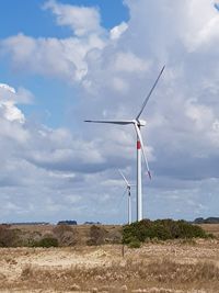 Windmill on field against sky