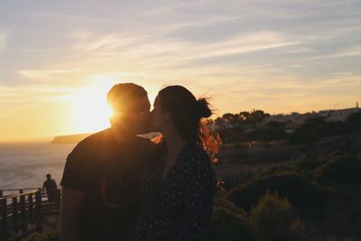 Couple standing against sky during sunset