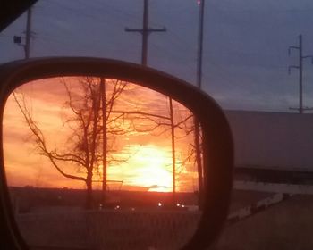 Close-up of car window against sunset sky