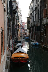Boats moored in canal amidst buildings in venice