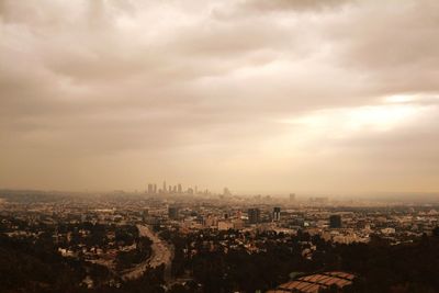 Cityscape against cloudy sky