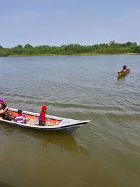 People sitting on boat in lake