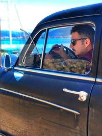 Man sitting on car window