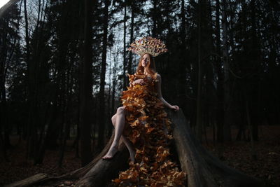 Woman with tree trunk in forest