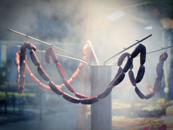 Close-up of hanging against sky