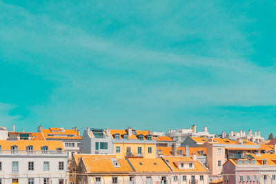 Buildings in city against blue sky