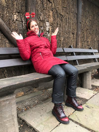 Full length portrait of happy woman sitting on seat