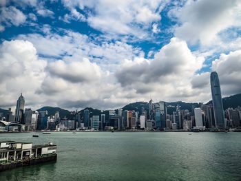 Sea by buildings against sky