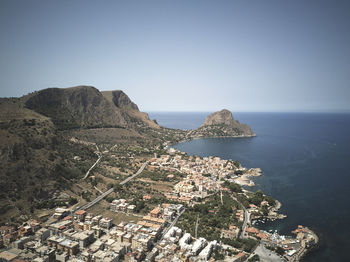 Aerial view of sea and buildings against clear sky