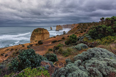 Rock formations on beach against sky