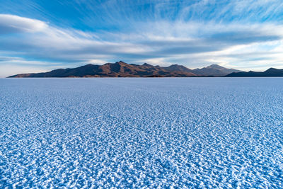 Scenic view of the uyuni salt flats or samar de uyuni against blue sky in southwest bolivia