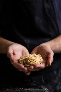 Cropped hand of man holding ramen noodles 