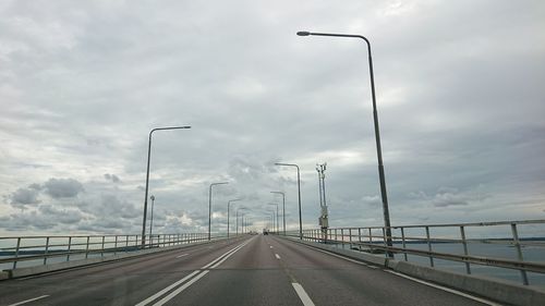 Street lights on bridge against sky