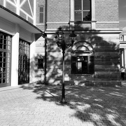 Street light on footpath by building