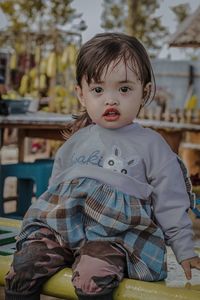 Portrait of cute boy sitting outdoors