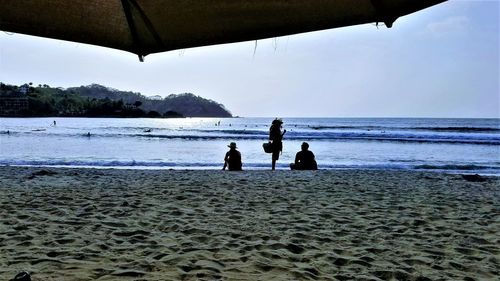 People on beach against sky