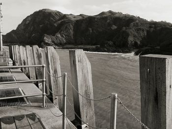 Fence on beach against sky