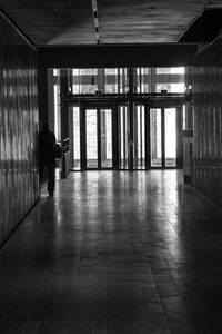 Rear view of man walking in corridor of building