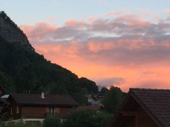 Houses in town against sky during sunset