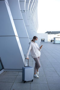 Full length of woman standing on tiled floor against sky