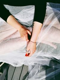 Low section of bride sitting on floorboard