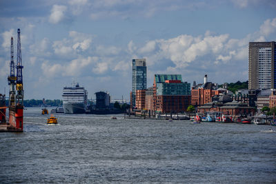 Sea by buildings against sky in city