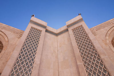 Low angle view of mosque hassan ii against blue sky